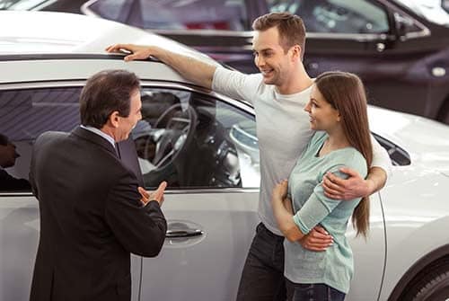 A couple purchasing a used vehicle - BENEFITS OF A USED TOYOTA concept image