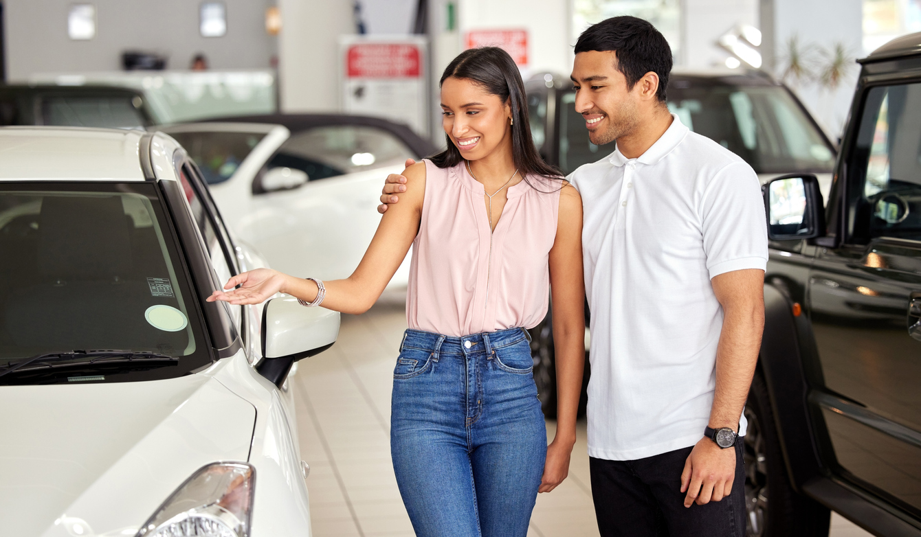 A young couple shopping for vehicle and speaking with major world Automotive Financing